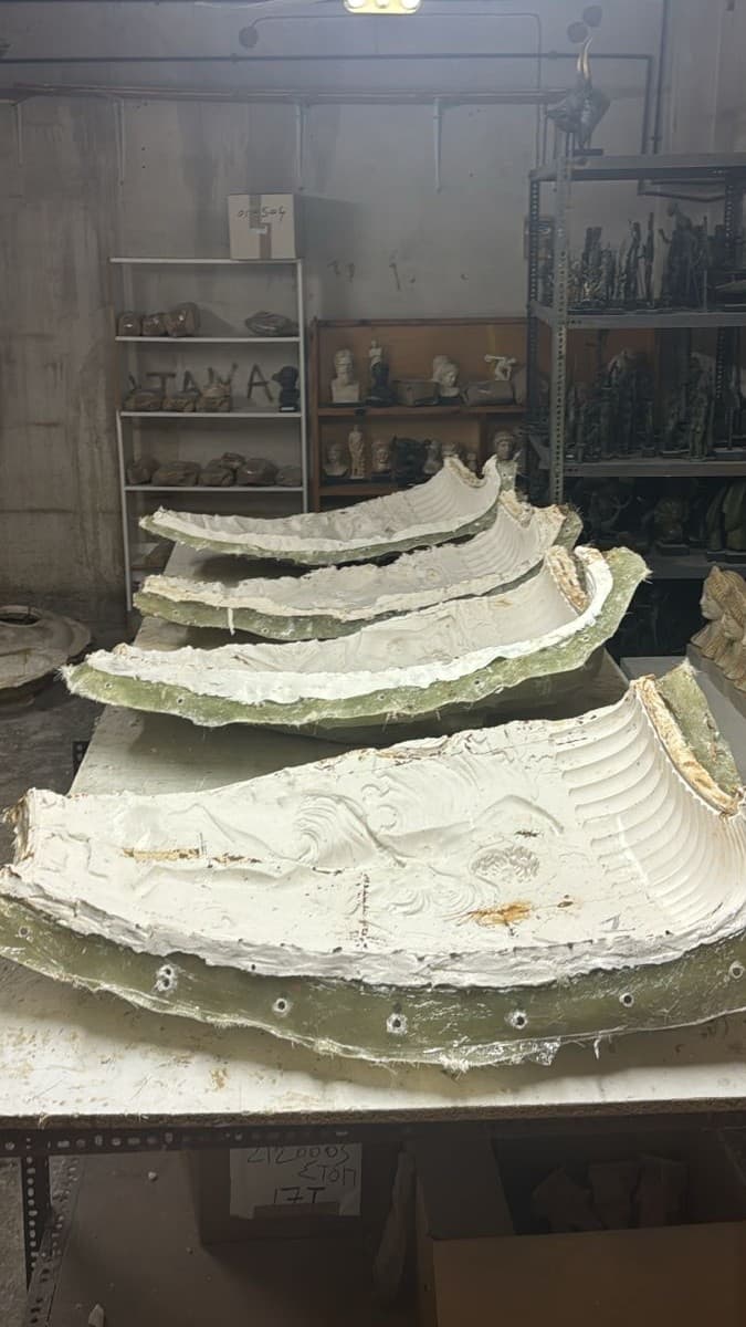 Plaster mould sections with the krater's sculpted relief laid out on a workshop table