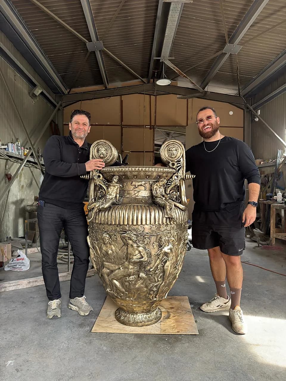 The monumental krater in the workshop, beside the artisans who made it